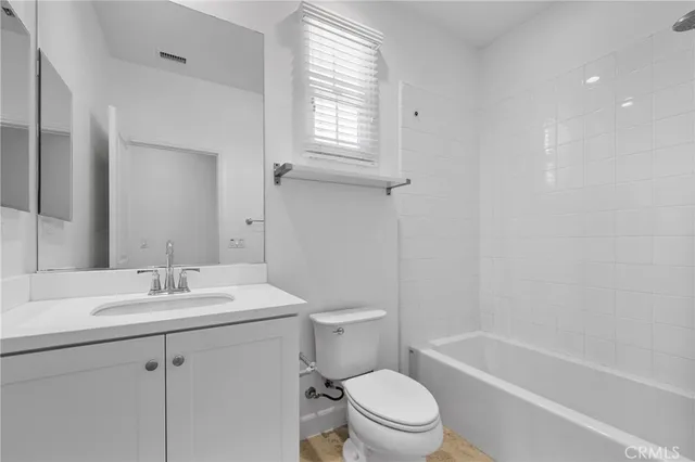 a bathroom with a sink toilet vanity and tub