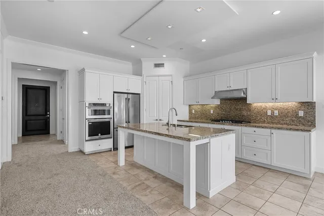 a kitchen with granite countertop a sink and white stainless steel appliances