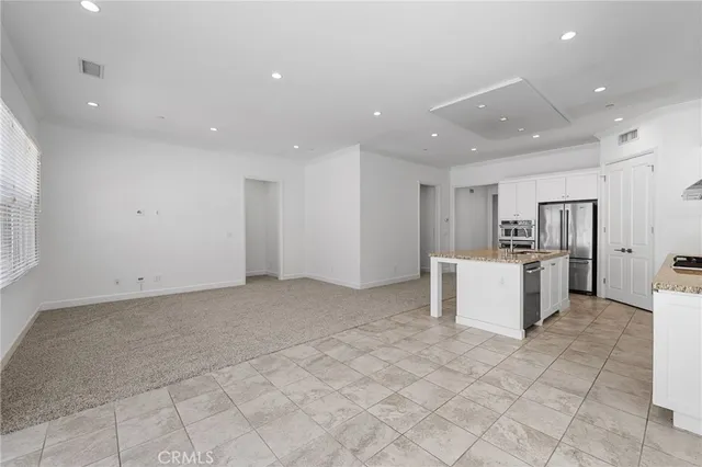 a large white kitchen with kitchen island a sink a counter top space and cabinets