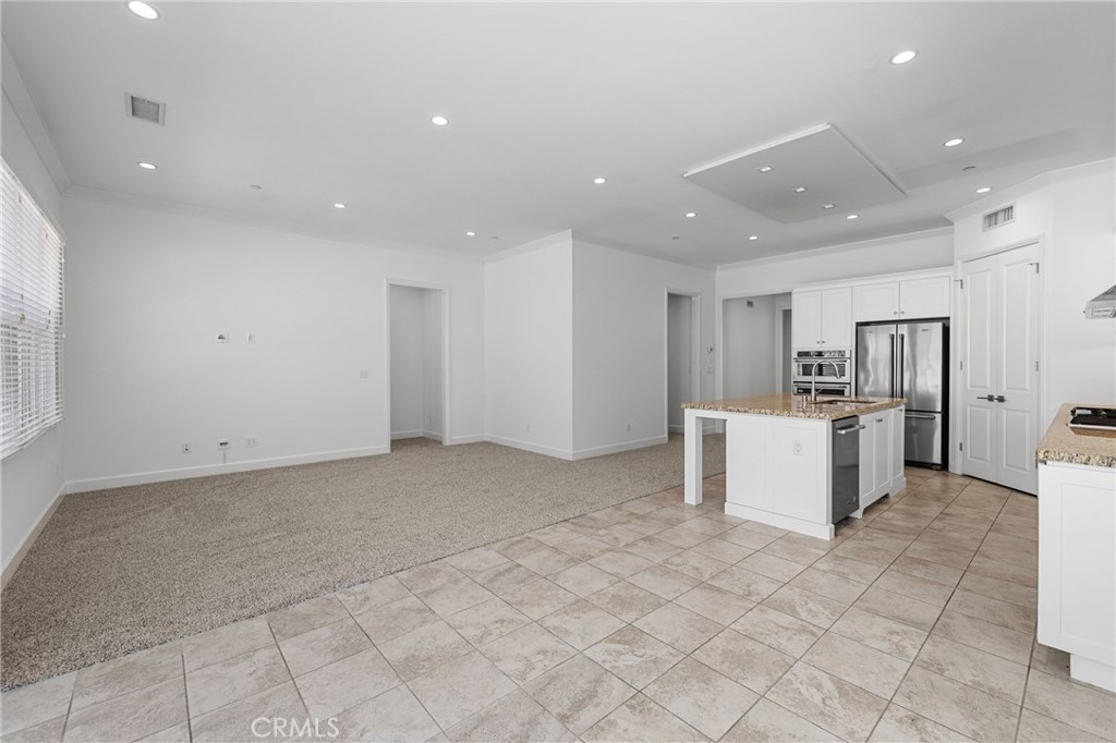 82 Meander Irvine, CA 92620 - Photo 8 of 32 a large white kitchen with kitchen island a sink a counter top space and cabinets