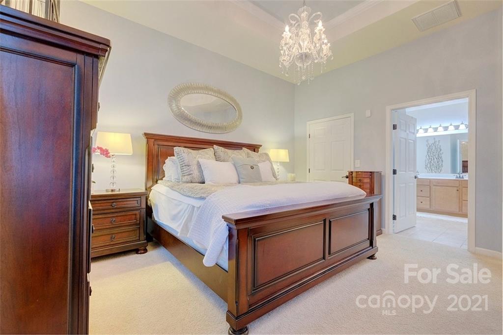 126 Inlet Point Drive Tega Cay, SC 29708 - Photo 14 of 34 a bedroom with a bed and a chandelier