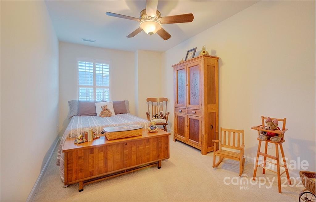 126 Inlet Point Drive Tega Cay, SC 29708 - Photo 22 of 34 a bedroom with a bed and a chandelier
