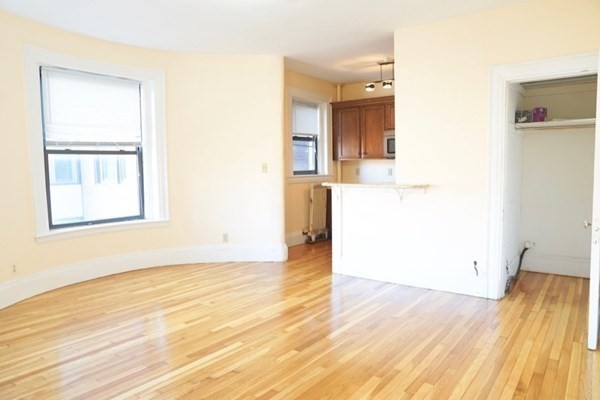an empty room with wooden floor and a window