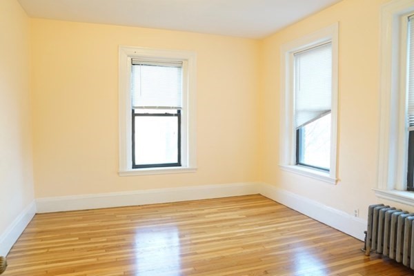 1091 Boylston Street, Unit 36 Boston, MA 02215 - Photo 5 of 7 a view of an empty room with wooden floor and a window