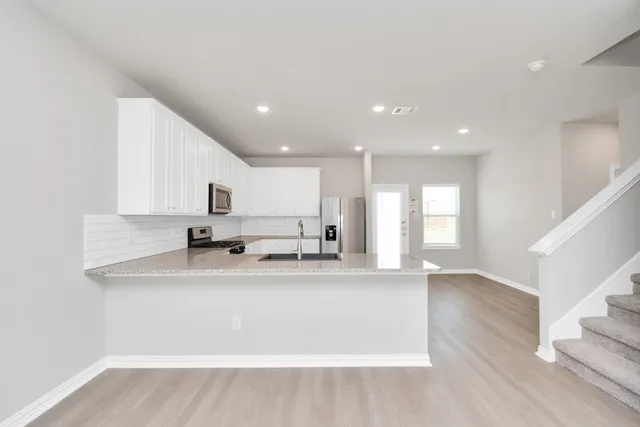 a kitchen with a refrigerator sink and stove