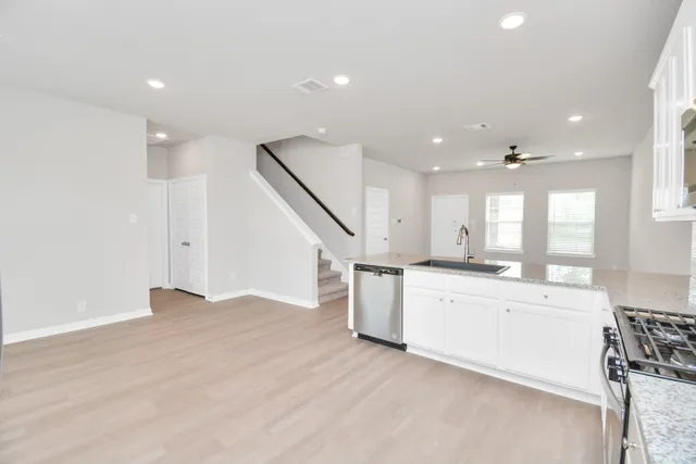 a view of a kitchen with a sink and wooden floor