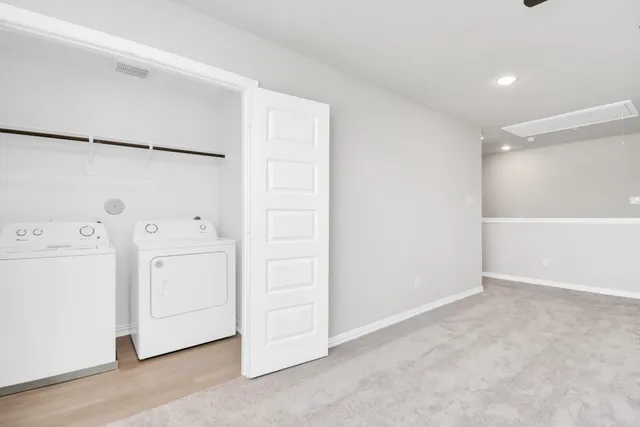 an empty room with windows and ceiling fan