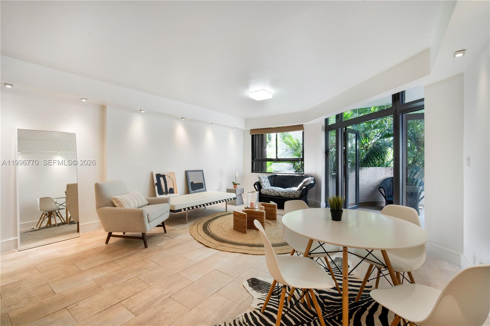 181 Crandon Boulevard, Unit 104 Key Biscayne, FL 33149 - Photo 1 of 28 a living room with furniture a large window and dining table