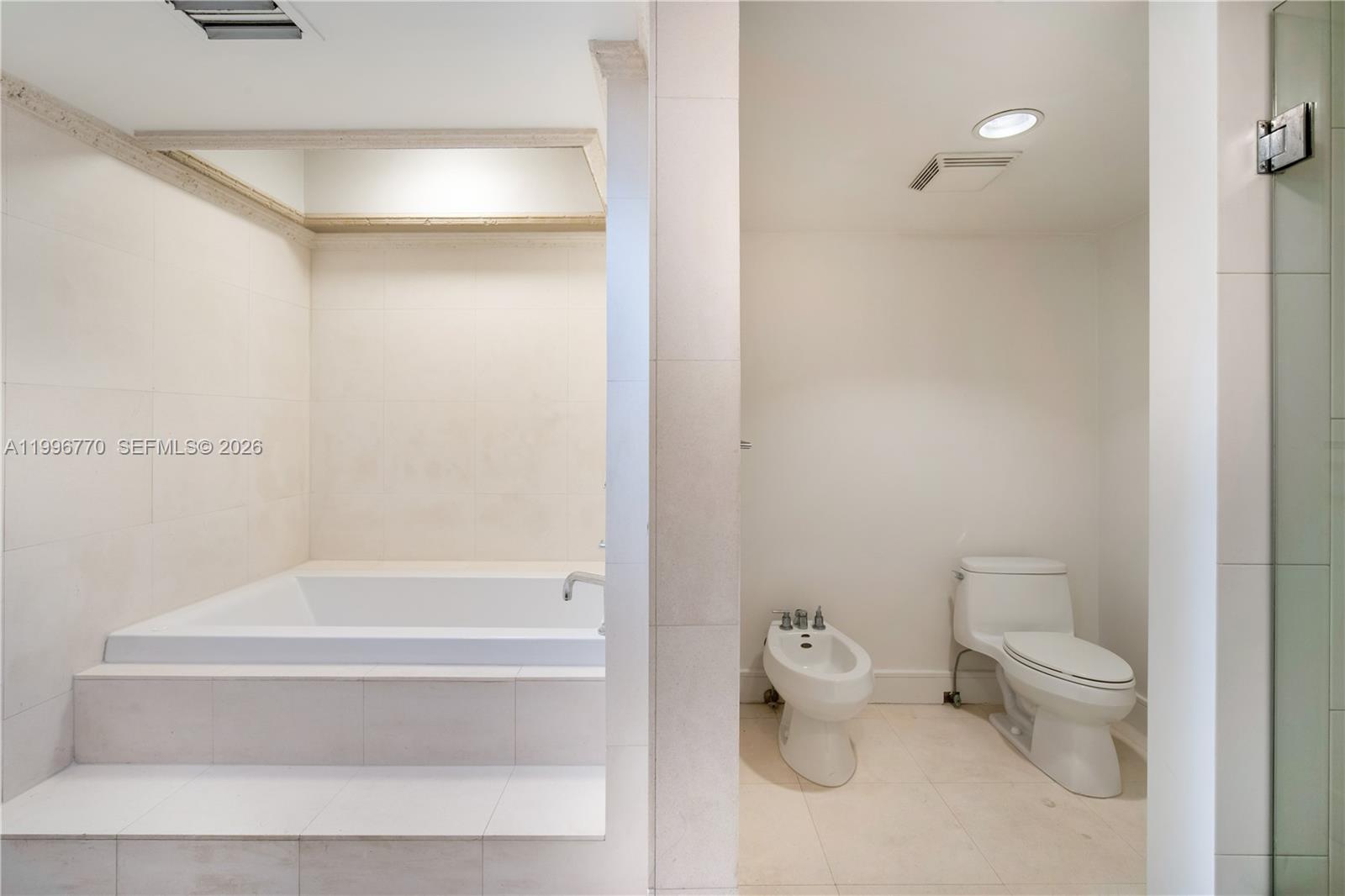 181 Crandon Boulevard, Unit 104 Key Biscayne, FL 33149 - Photo 17 of 28 a bathroom with a toilet and a bathtub