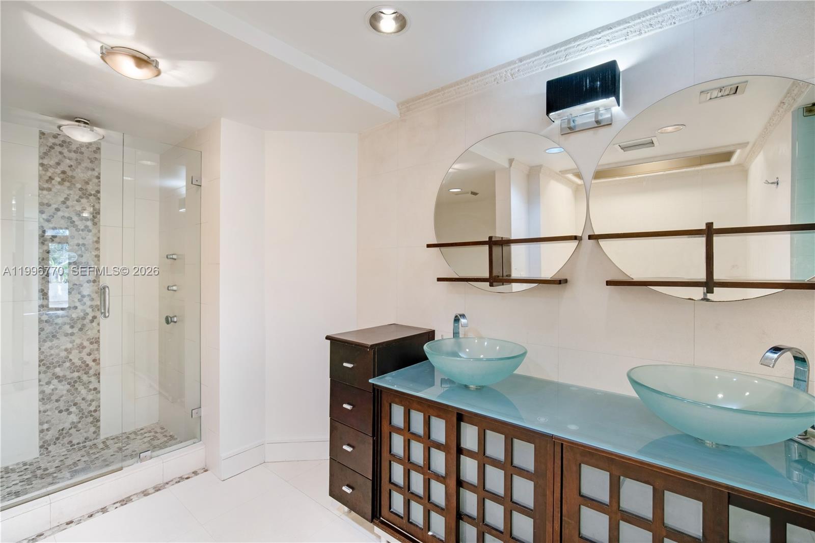 181 Crandon Boulevard, Unit 104 Key Biscayne, FL 33149 - Photo 18 of 28 a bathroom with a sink and a mirror