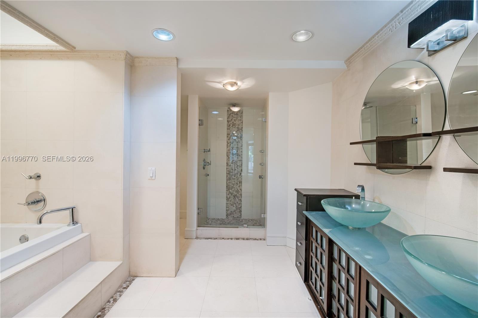 181 Crandon Boulevard, Unit 104 Key Biscayne, FL 33149 - Photo 19 of 28 a bathroom with a double vanity sink a mirror and shower