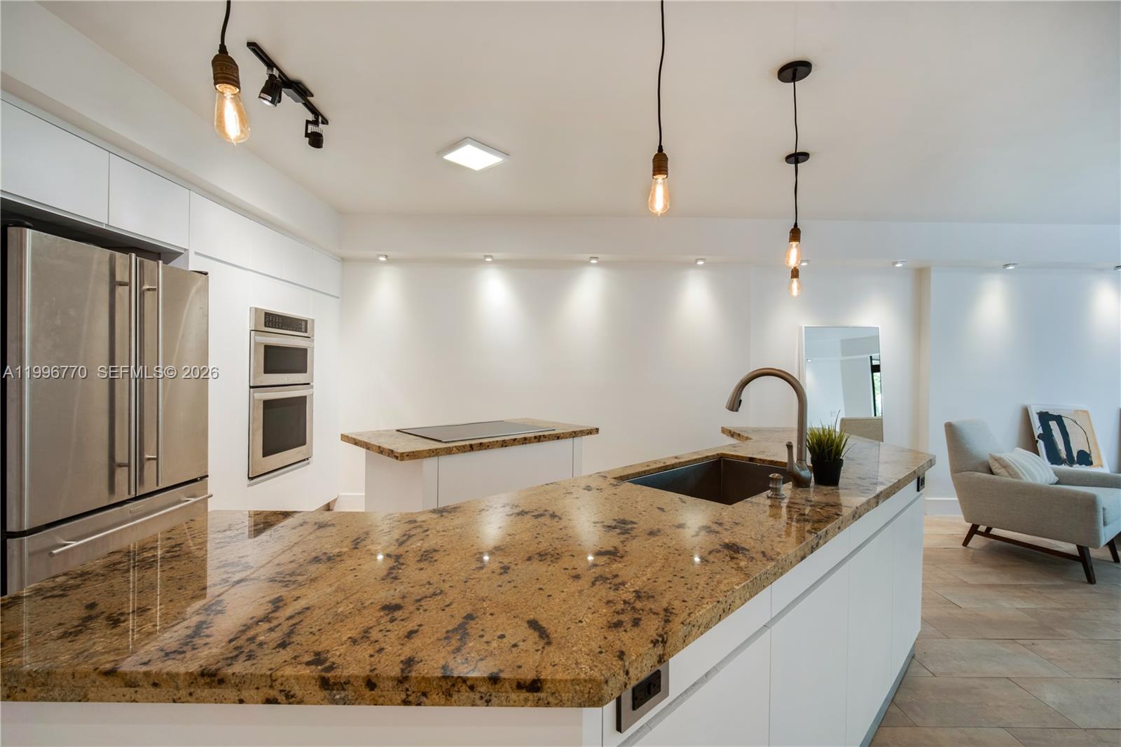 181 Crandon Boulevard, Unit 104 Key Biscayne, FL 33149 - Photo 4 of 28 a kitchen with stainless steel appliances granite countertop a sink refrigerator and cabinets