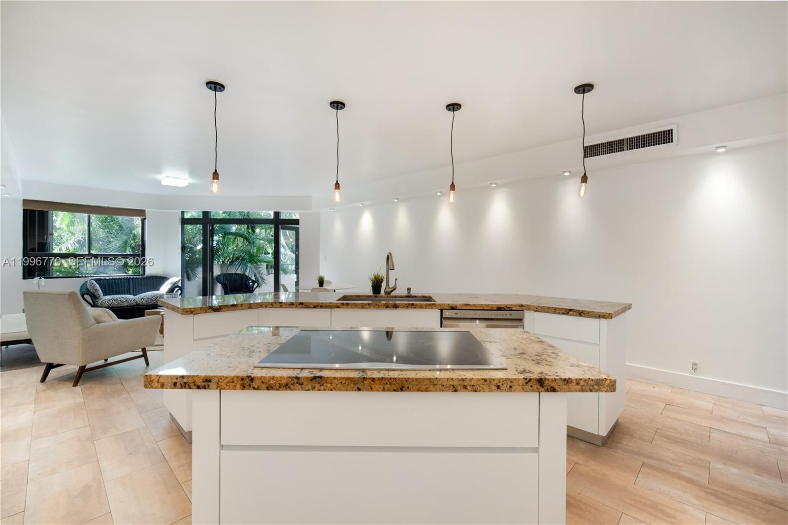 181 Crandon Boulevard, Unit 104 Key Biscayne, FL 33149 - Photo 6 of 28 a view of a kitchen with kitchen island a counter top space a sink and living room view