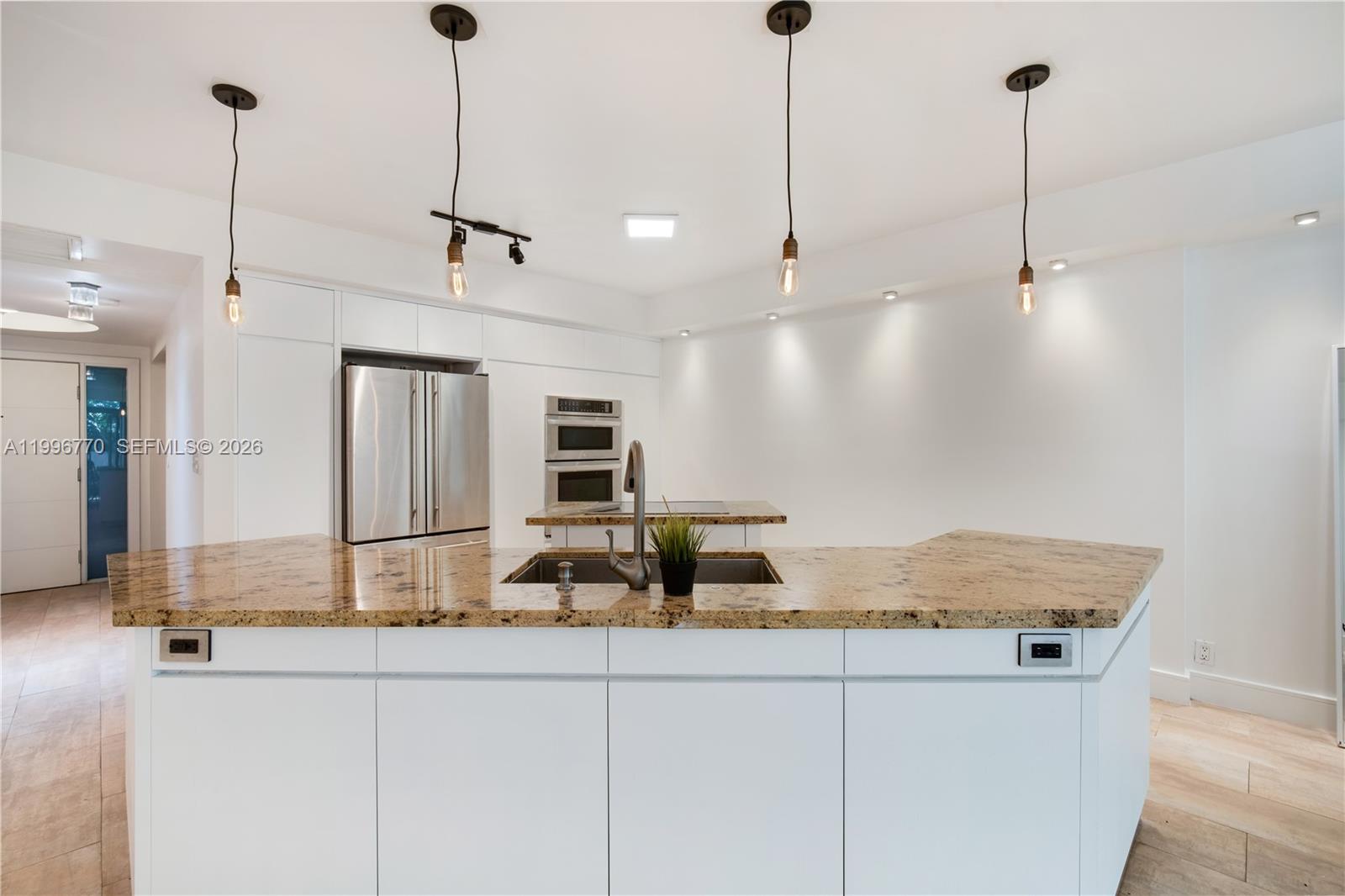 181 Crandon Boulevard, Unit 104 Key Biscayne, FL 33149 - Photo 7 of 28 a kitchen with kitchen island a counter top space appliances and a counter top