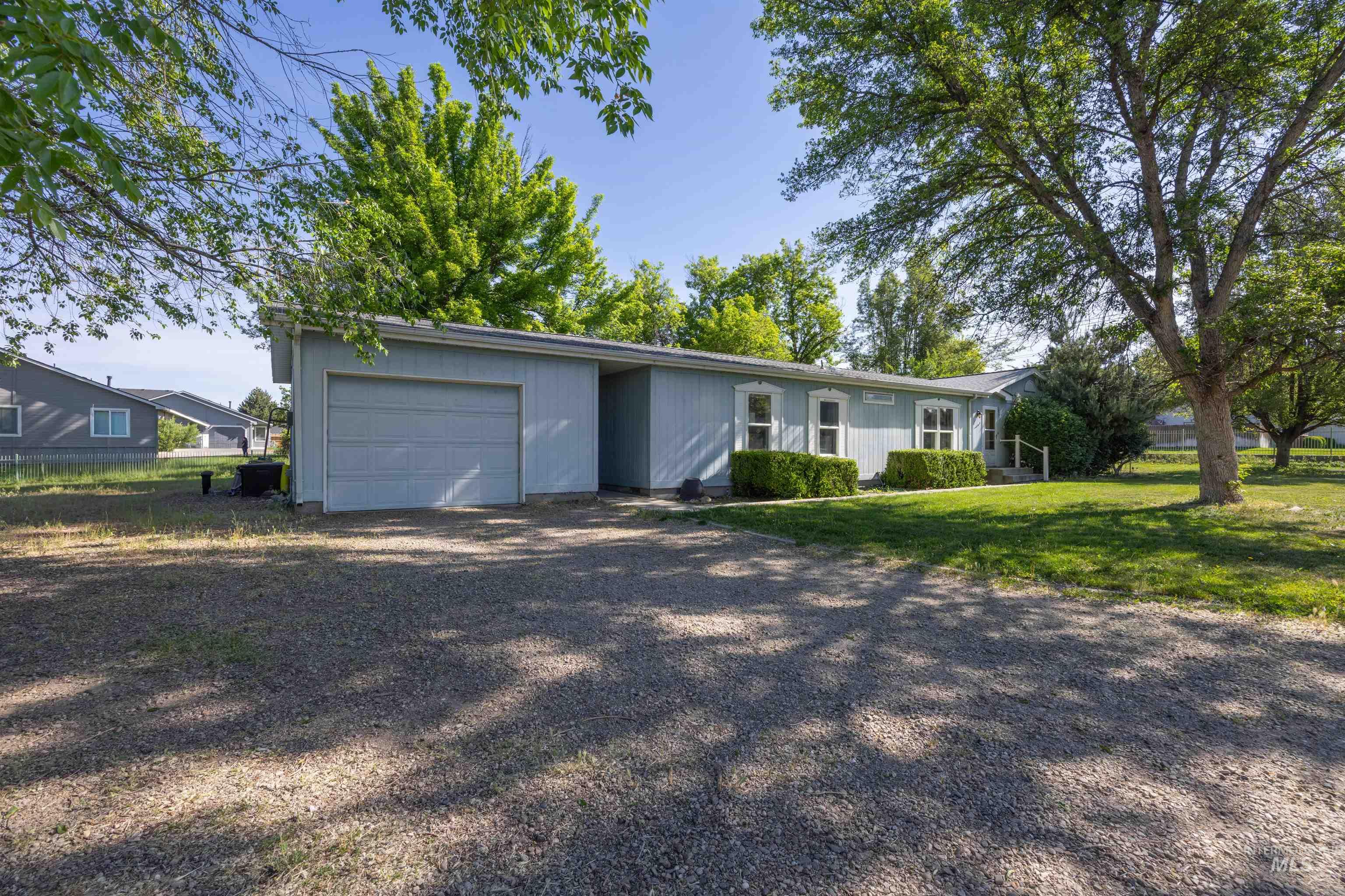 2875 North Maple Grove Road Boise, ID 83704 - Photo 1 of 1 Light blue siding exterior with a gravel driveway and an attached garage