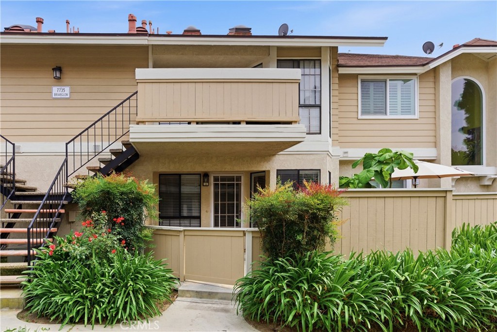 a view of a house with potted plants and a table