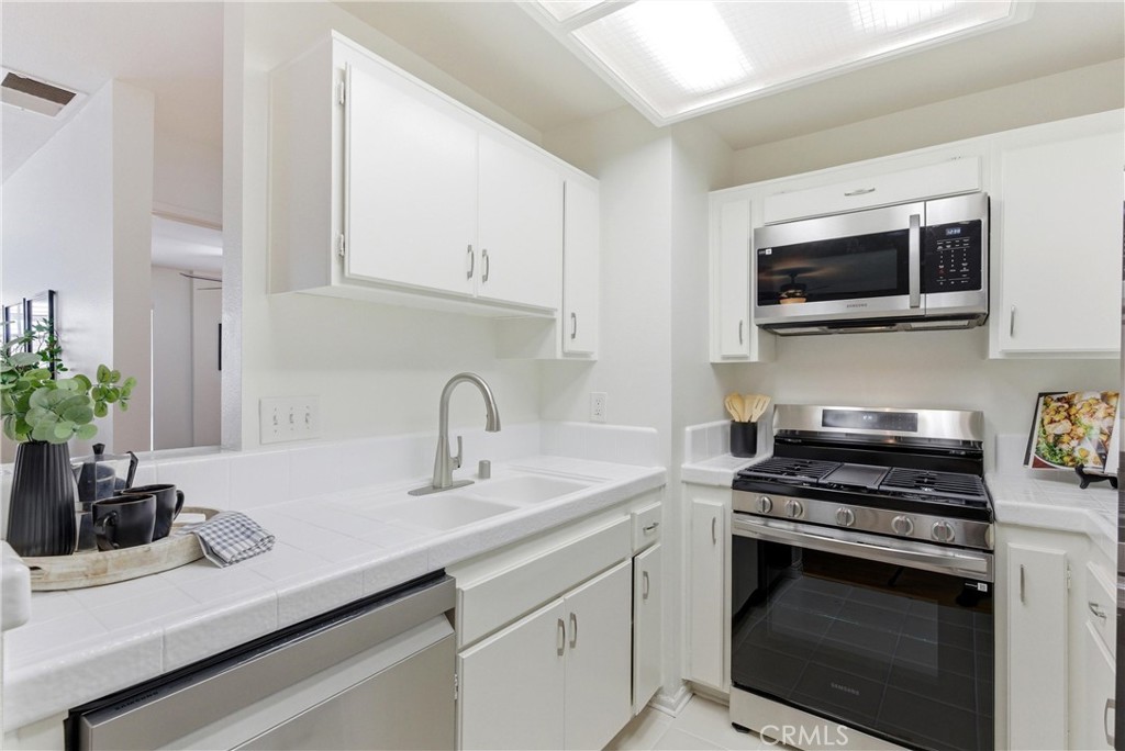 7735 Briarglen Loop, Unit I Stanton, CA 90680 - Photo 11 of 32 a kitchen with a sink and stove top oven