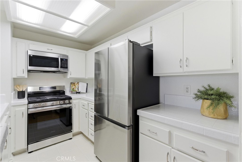 7735 Briarglen Loop, Unit I Stanton, CA 90680 - Photo 13 of 32 a kitchen with a refrigerator and a stove top oven