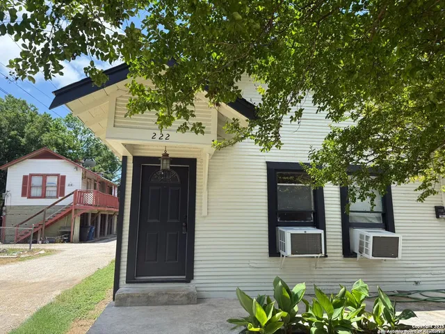 a front view of a house with potted plants