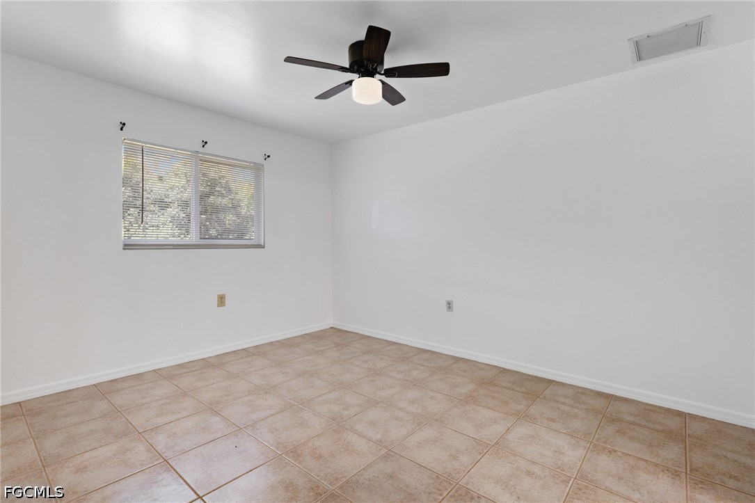 221 Meadow Road Lehigh Acres, FL 33973 - Photo 12 of 13 an empty room with ceiling fan and window