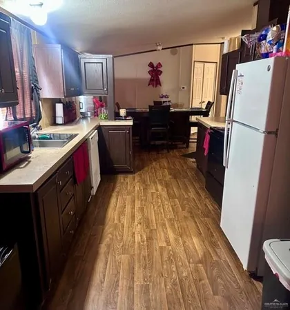 a kitchen with kitchen island wooden floors appliances