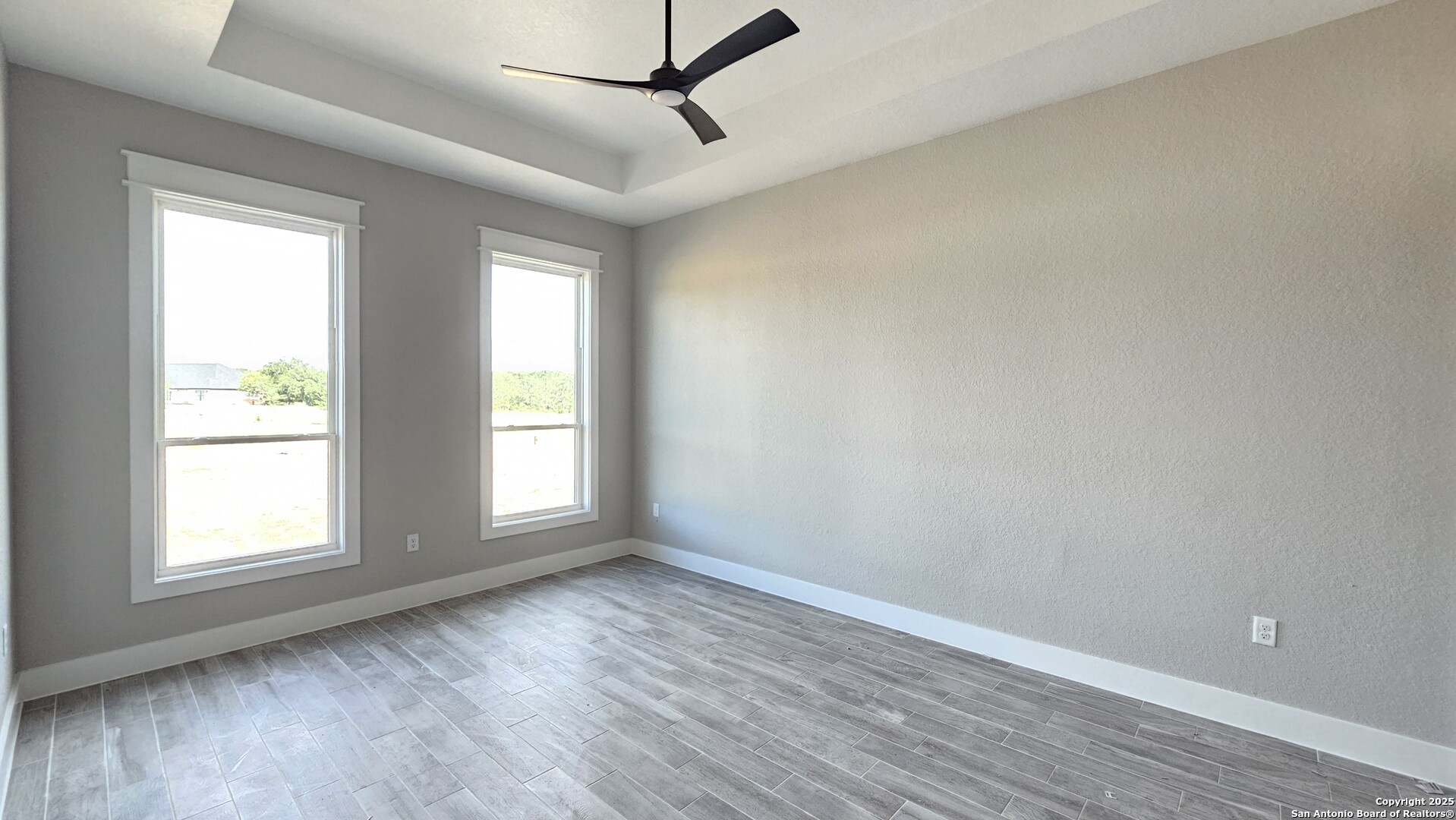699 James Way Castroville, TX 78009 - Photo 18 of 31 an empty room with wooden floor and windows
