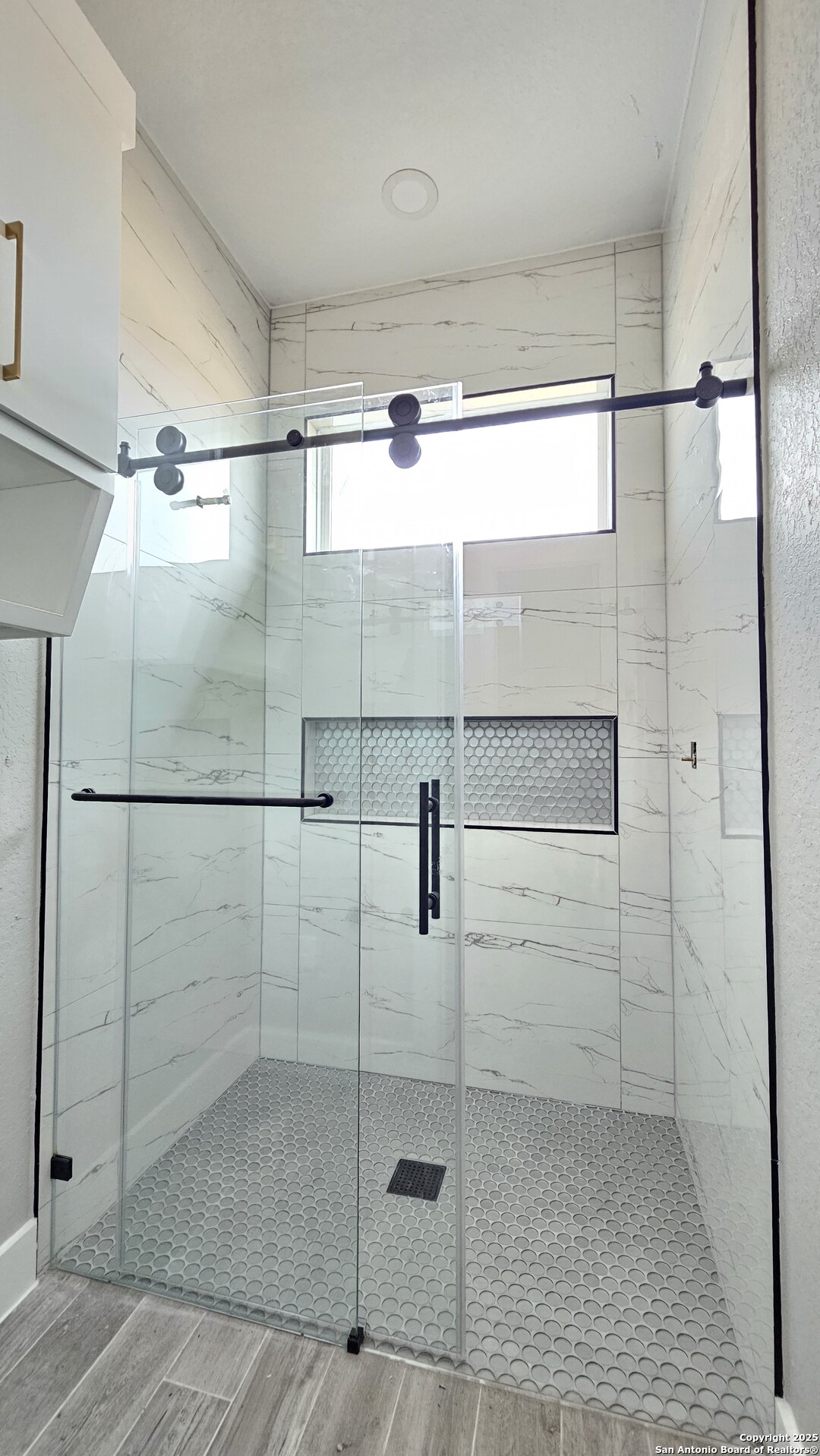 699 James Way Castroville, TX 78009 - Photo 20 of 31 a bathroom with a glass shower door