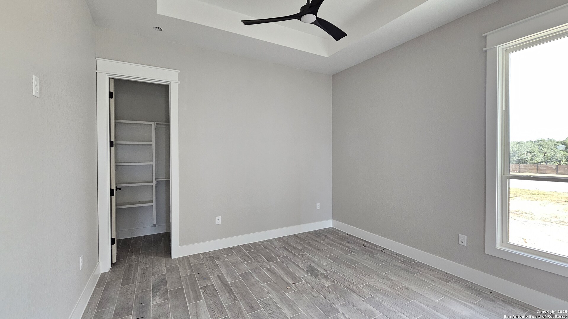 699 James Way Castroville, TX 78009 - Photo 24 of 31 an empty room with a window and wooden floor