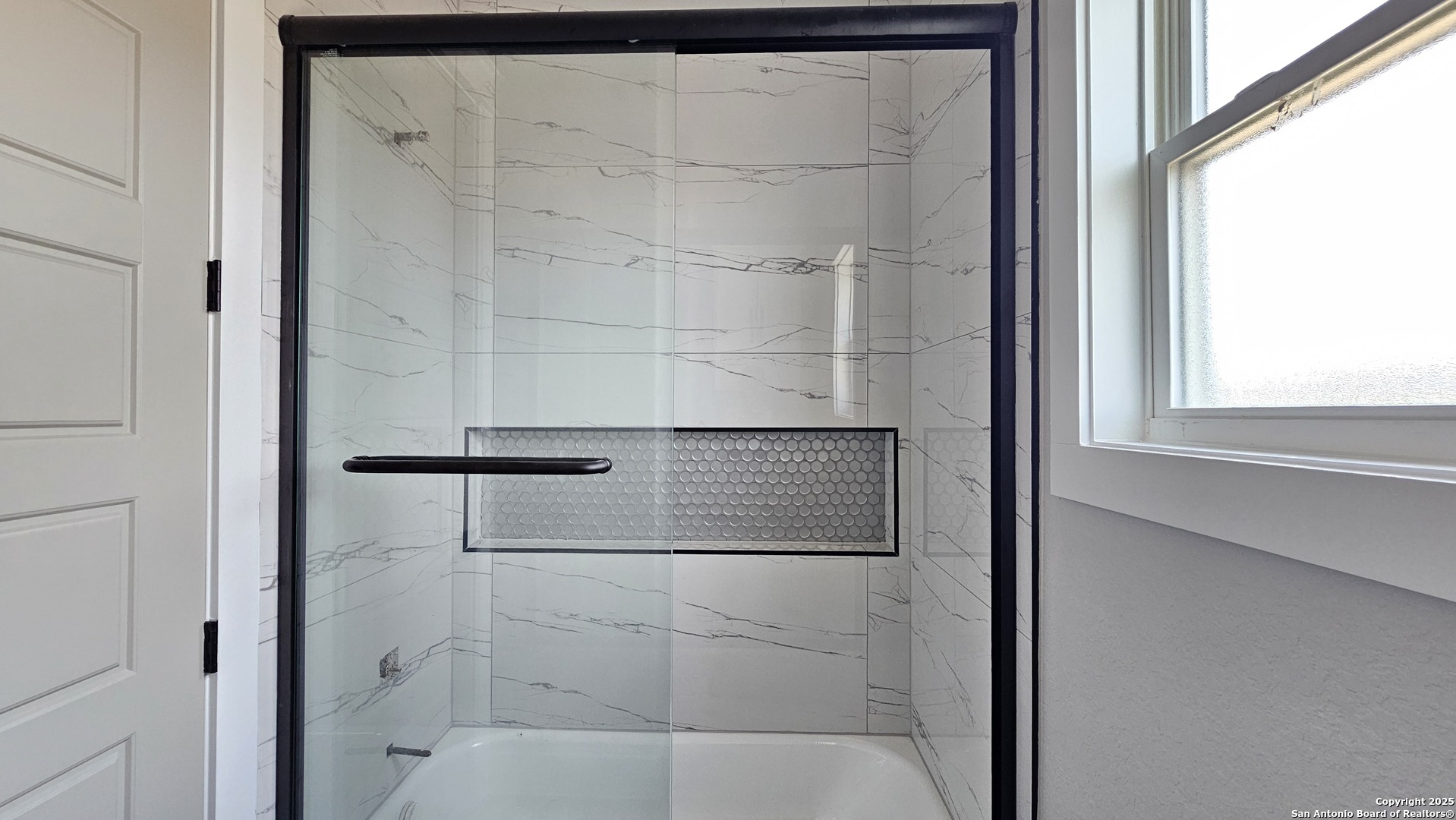 699 James Way Castroville, TX 78009 - Photo 27 of 31 a bathroom with a glass shower door