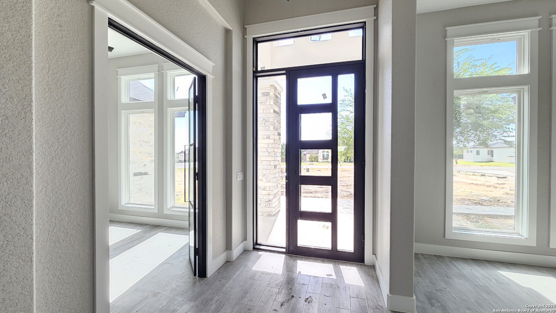 699 James Way Castroville, TX 78009 - Photo 6 of 31 an empty room with wooden floor and windows