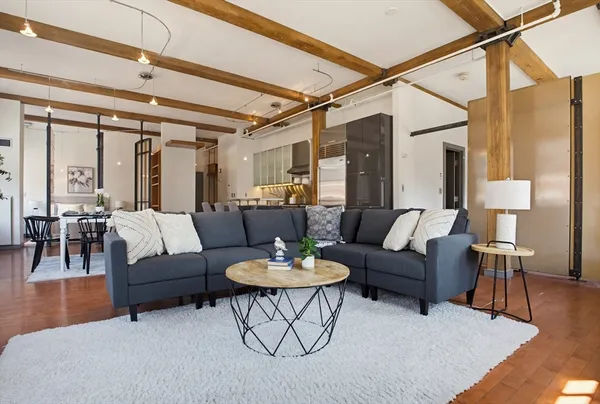 a living room with furniture and a wooden floor