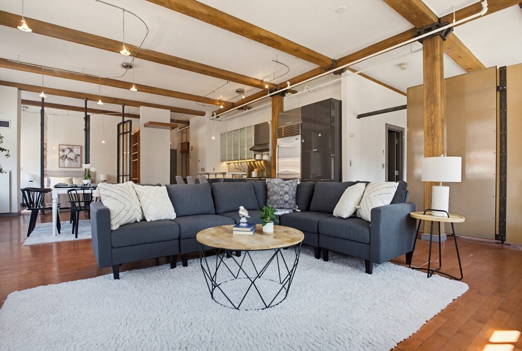 a living room with furniture and a wooden floor