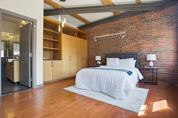 a bedroom with a bed and wooden floor