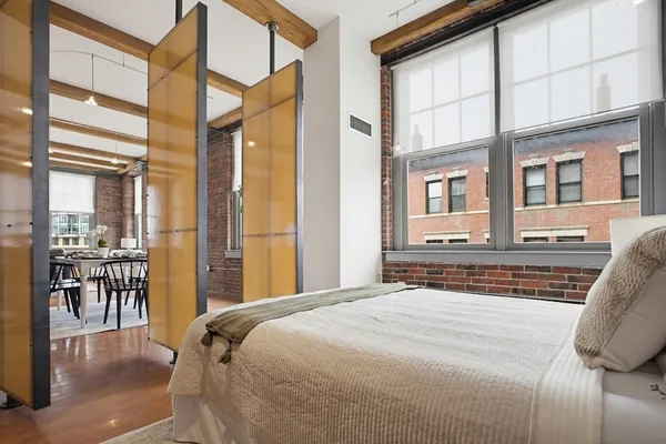 a bedroom with a large window and a bed