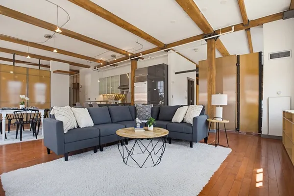 a living room with furniture and a wooden floor