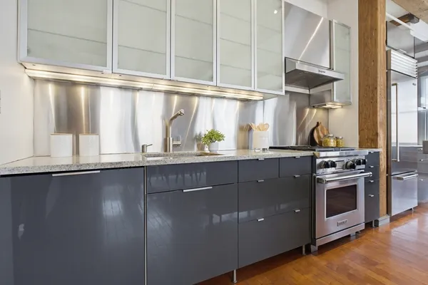 a kitchen with stainless steel appliances granite countertop a sink a stove and a wooden floors