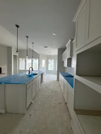 a large kitchen with kitchen island a stove a sink a center island in the center