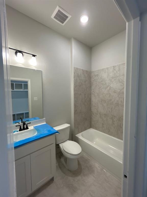 8935 County Road 623 Blue Ridge, TX 75424 - Photo 12 of 17 Full bathroom featuring a white vanity with black hardware, a toilet, and a bathtub with tiled surround