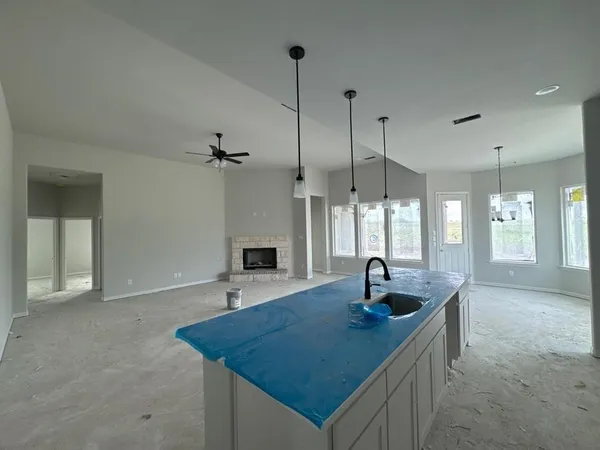 a kitchen with a sink a window and chairs