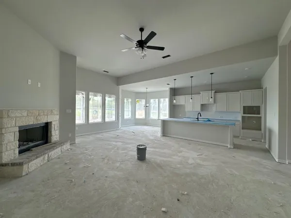 a view of an empty room with a fireplace and a window