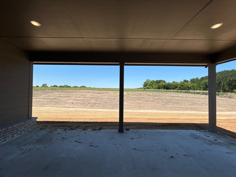 8935 County Road 623 Blue Ridge, TX 75424 - Photo 16 of 17 Covered concrete patio with recessed lighting and a brick accent wall, featuring open field views