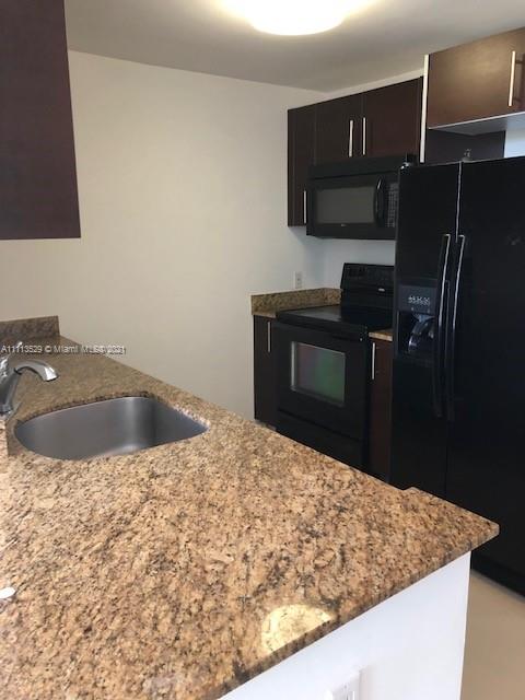 2701 Southwest 3rd Avenue, Unit 705 Miami, FL 33129 - Photo 5 of 10 a kitchen with a sink and a refrigerator