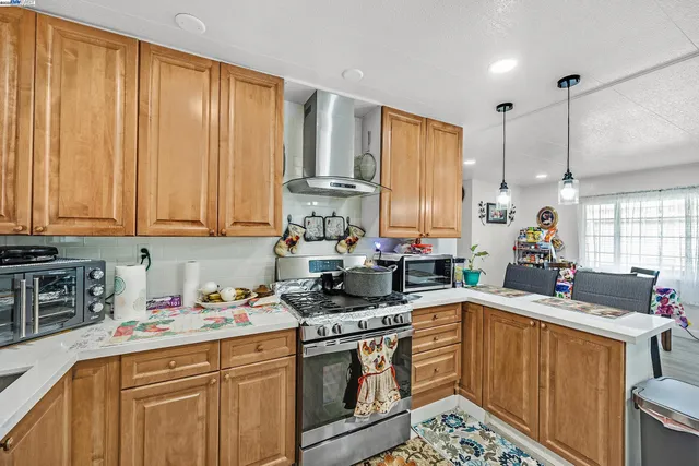 a kitchen with stainless steel appliances a stove a sink a cabinets and wooden floor