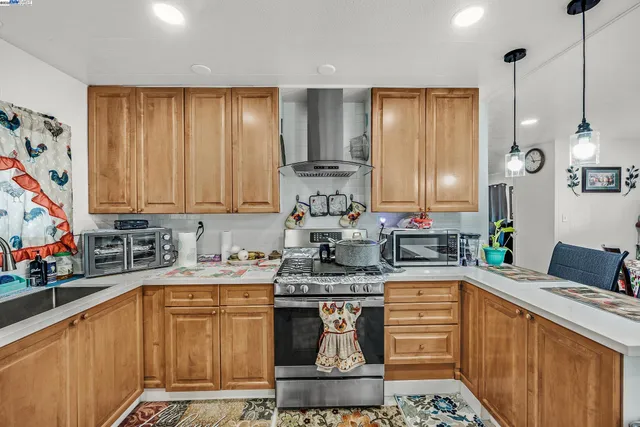 a kitchen with stainless steel appliances granite countertop a sink stove and cabinets