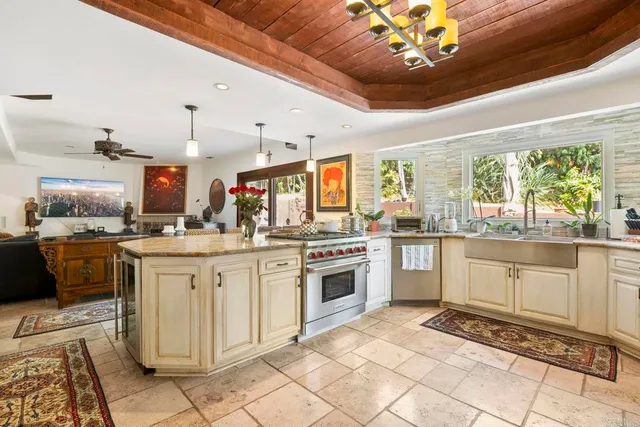a kitchen with stainless steel appliances granite countertop a stove and white cabinets