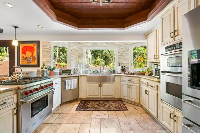 a kitchen with stainless steel appliances granite countertop a refrigerator and a stove top oven