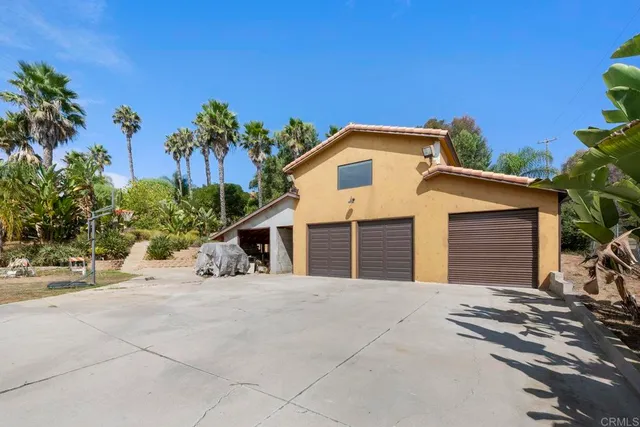 an aerial view of residential house with outdoor space and trees all around