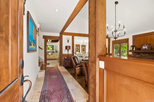 a living room with furniture a fireplace and a chandelier
