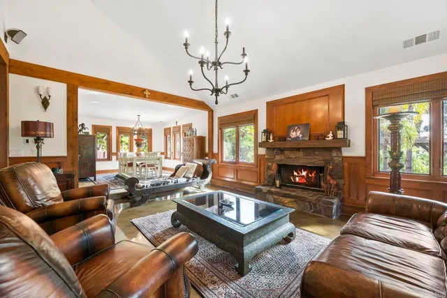 a living room with fireplace furniture and a chandelier