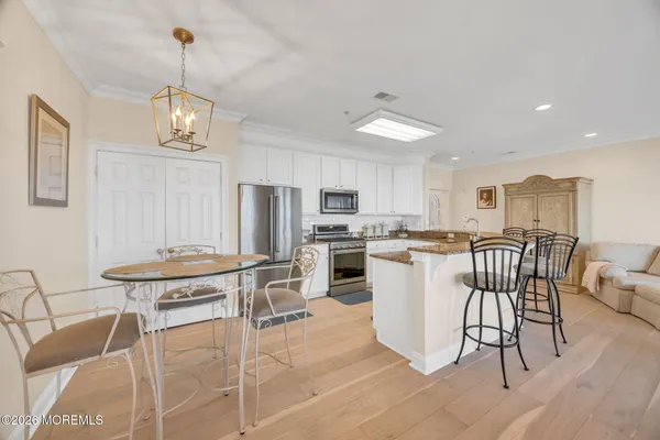a kitchen with a dining table chairs and refrigerator